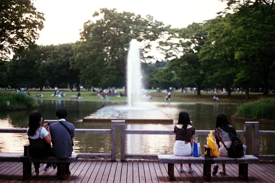 Young adults sitting and watching a fountain in Yoyogi Park, Tokyo